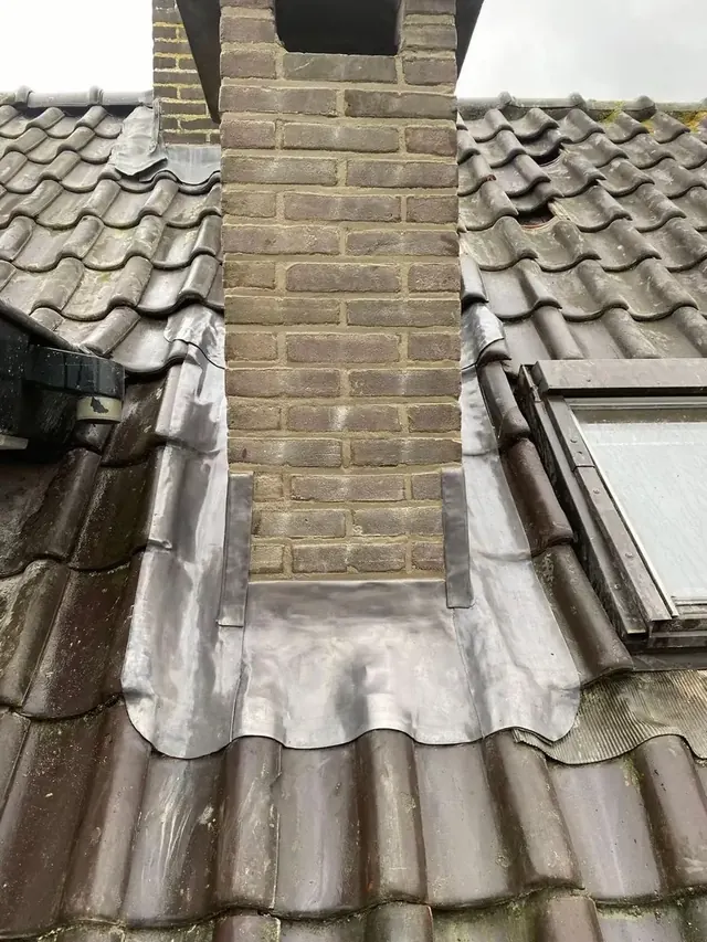 Lood rond een schoorsteen — Voor- en zijaansluitingen tussen de gemetselde schoorsteen en de dakpannen.