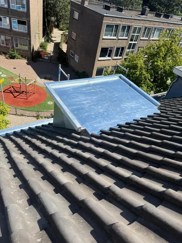 Zinken dak op een dakkapel — Het metalen dakkapeldak sluit aan op een schuin pannendak.